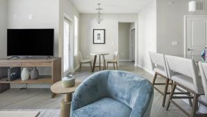 uma sala de estar com uma cadeira azul e uma televisão em Landing - Modern Apartment with Amazing Amenities (ID1245X807) em League City