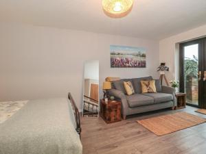 uma sala de estar com uma cama e um sofá em Piglet Corner em Culmstock