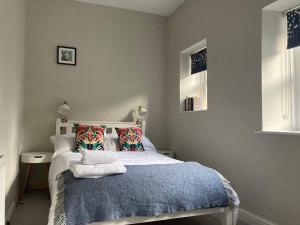 レイバーンにあるPony Cube Cottageのベッドルーム1室(青い毛布と枕付きのベッド1台付)