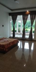 a bedroom with a bed and a large window at Hotel Radha Rani Mahal in Khajurāho