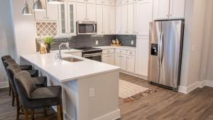 a kitchen with white cabinets and a stainless steel refrigerator at Landing - Modern Apartment with Amazing Amenities (ID1372X711) in Franklin