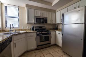 a kitchen with white cabinets and a stainless steel refrigerator at Landing - Modern Apartment with Amazing Amenities (ID1793X49) in Phoenix