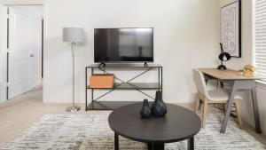 sala de estar con TV y mesa en Landing - Modern Apartment with Amazing Amenities (ID6950X30), en Houston