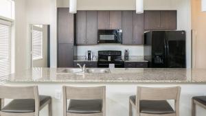 una cocina con una isla con sillas y una encimera en Landing - Modern Apartment with Amazing Amenities (ID6950X30), en Houston