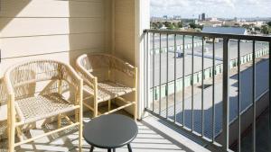 2 sillas y una mesa en el balcón en Landing - Modern Apartment with Amazing Amenities (ID6950X30), en Houston