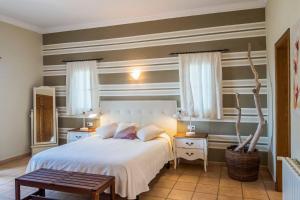 una camera con un letto bianco e due tavoli di Villa Alaris a Santo Tomás