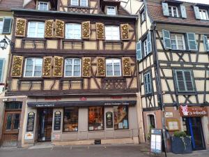 een hoog gebouw met een winkel ervoor bij LE GITE in Colmar