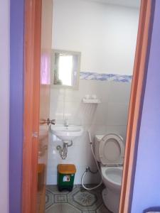 a small bathroom with a toilet and a sink at Purple Guesthouse in Nasugbu