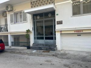 un edificio blanco con puerta y garaje en ΑKTIS apartment 2 near airport, en Artemida