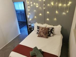 a bedroom with a bed with lights on the wall at Feather Rest in Bloemfontein