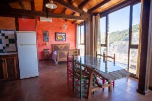 Una cocina y un comedor con mesa y sillas. en Casa Rural Los Ventanales, en Alcalá del Júcar
