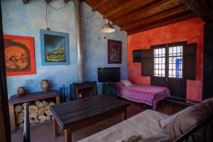 a living room with a couch and a table and a fireplace at Casa Rural Los Ventanales in Alcalá del Júcar