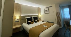 una camera d'albergo con un grande letto con cuscini di Kyriad Beaune a Beaune
