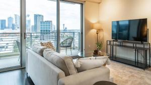 a living room with a couch and a flat screen tv at Landing - Modern Apartment with Amazing Amenities (ID1513X37) in Dallas