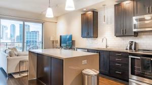 une cuisine avec un comptoir et un salon dans l'établissement Landing - Modern Apartment with Amazing Amenities (ID1513X37), à Dallas