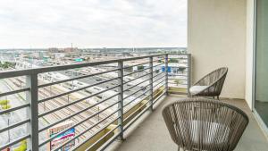 a balcony with two chairs and a view of a city at Landing - Modern Apartment with Amazing Amenities (ID1513X37) in Dallas