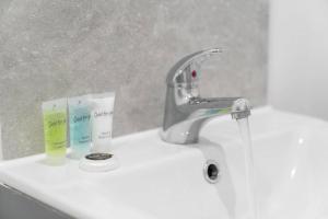 a bathroom sink with a faucet and two toothbrushes at Modern Apartment - Twin Beds - Free Netflix & Wifi - Parking - Top Rated - 7OC in Brierley Hill