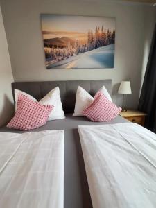 a bedroom with two beds with pink and white pillows at Summit Alps Apartments - Inclusive Bergbahntickets in Oberjoch