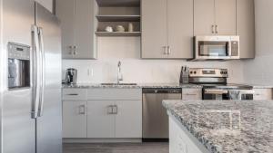 a kitchen with white cabinets and a white refrigerator at Landing - Modern Apartment with Amazing Amenities (ID8375X72) in Middleburg
