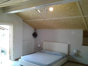 Candelo的住宿－La Mansarda Dell'Artista，一间卧室设有一张床和天花板