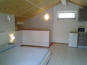 1 dormitorio pequeño con 1 cama y cocina en La Mansarda Dell'Artista en Candelo