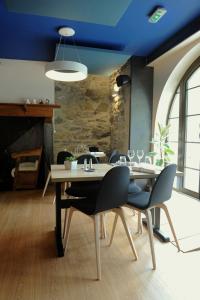 comedor con mesa y sillas y techo azul en Logis Hôtel La Brèche de Roland, en Gèdre