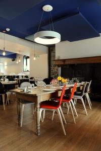 una sala da pranzo con tavoli, sedie e soffitto blu di Logis Hôtel La Brèche de Roland a Gèdre