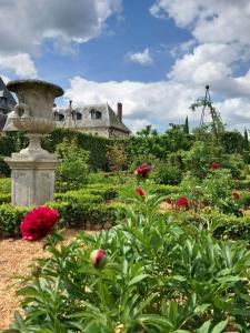 a garden with red flowers and a house in the background at Domaine du Bosc Roger in Bouquetot +11 photos