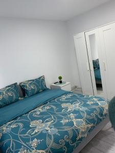 um quarto com uma cama com um edredão azul em Apartament Elena em Bîrlad