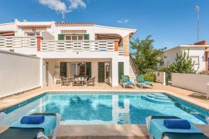 a villa with a swimming pool in front of a house at Villa Cati Punta Prima in Punta Prima