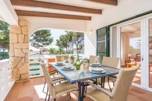 a dining room with a table and chairs on a balcony at Villa Cati Punta Prima in Punta Prima