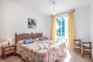 a bedroom with a large bed with blue pillows at Villa Cati Punta Prima in Punta Prima +21 photos