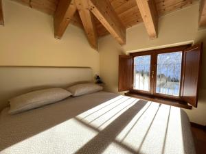 ポンテ・ディ・レーニョにあるAffittimoderni Ponte di Legno Skiのベッドルーム(大型ベッド1台、窓付)