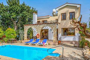 a villa with a swimming pool in front of a house at Villa Irene Polis in Polis Chrysochous