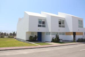 ein weißes Gebäude am Straßenrand in der Unterkunft Casa Z Paracas in Paracas