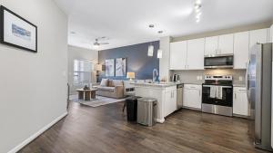 a kitchen with white cabinets and a living room at Landing - Modern Apartment with Amazing Amenities (ID8830X56) in San Antonio