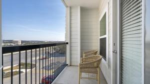d'un balcon avec deux chaises et une vue sur la rue. dans l'établissement Landing - Modern Apartment with Amazing Amenities (ID8830X56), à San Antonio