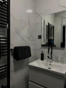 a white bathroom with a sink and a mirror at LuxRooms BJELOVAR in Bjelovar
