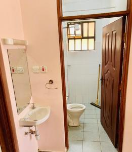 a bathroom with a sink and a toilet at Yonga Apartment in Kisumu