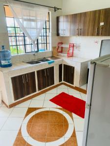 een keuken met houten kasten en een rood tapijt op de vloer bij Yonga Apartment in Kisumu