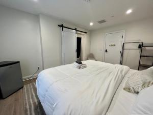 um quarto com uma grande cama branca e uma televisão em The Drift em Charleston