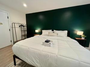 um quarto com uma grande cama branca e uma parede verde em The Drift em Charleston