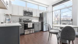 een keuken met witte apparatuur en een tafel en stoelen bij Landing - Modern Apartment with Amazing Amenities (ID8715X53) in Tower Grove