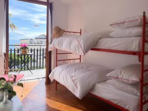 アーチ・カステッロにあるPalm House AciCastelloのバルコニー付きのドミトリールームの二段ベッド2台分です。