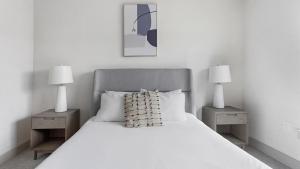 1 dormitorio con 1 cama blanca y 2 mesitas de noche en Landing - Modern Apartment with Amazing Amenities (ID5286X10) en Richmond