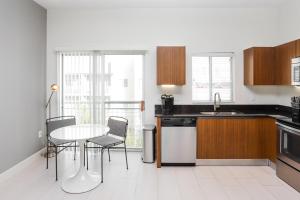 a kitchen with a table and chairs and a sink at Landing - Modern Apartment with Amazing Amenities (ID2654) in Tampa