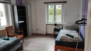 a bedroom with a bed and a desk and two windows at Monteurwohnung bis 6 Personen mit 4 gratis Parklätzen und Grill und WLAN 3x Schlafzimmer in Veitshöchheim
