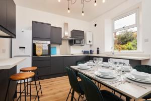 a kitchen with a table and chairs and a kitchen with a counter at Cosy, Stylish, Leafy And Homely in Sheffield