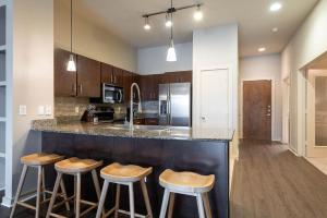 a kitchen with a counter and bar stools in it at Landing - Modern Apartment with Amazing Amenities (ID1776X11) in Austin