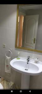 y baño con lavabo blanco y espejo. en Gran piso familiar, en Córdoba